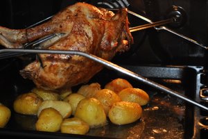 Le poulet rôti et les pommes de terre dans le four